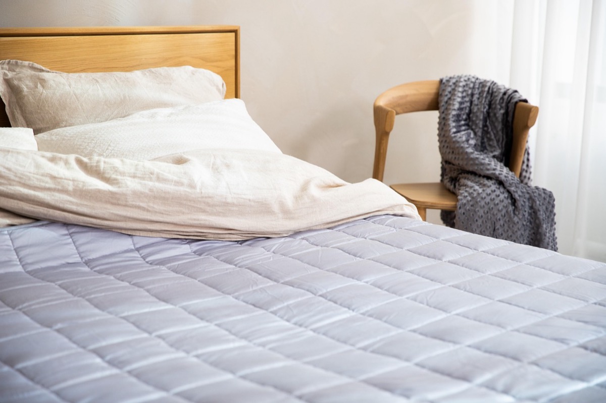 Matelas neuf et linge de lit dans une chambre rénovée aux tons clairs